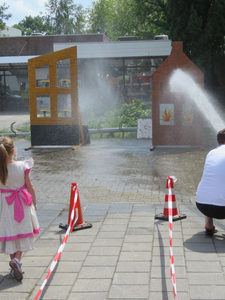 844105 Afbeelding van enkele kinderen die met de hulp van brandweerlieden op een doel mogen spuiten, bij het grote ...